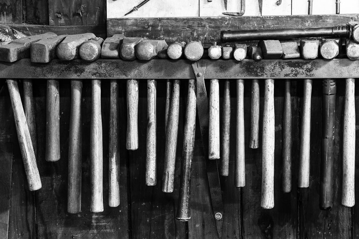 Row of hammers in a working blacksmith shop. Black and white photograph by Keith Dotson.