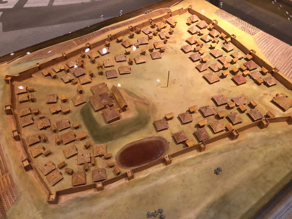 A model Mississippian era village, like the Sellars Farm site where Sandy and his wife were discovered. Note the dark, shining river on the far perimeter and the palisade wall all around. Seen at the McClung Museum of Natural History and Culture at University of Tennessee, Knoxville.