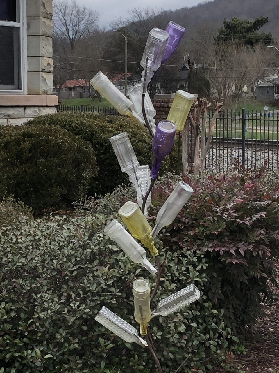 A bottle tree, a practice brought with enslaved people from Africa and introduced originally in the Carolina Low Country. Bottle trees were used to capture haints, evil spirits from the beliefs of the Gullah-Geechee culture. This bottle tree was outside a small railroad museum in Ft. Payne, Alabama.