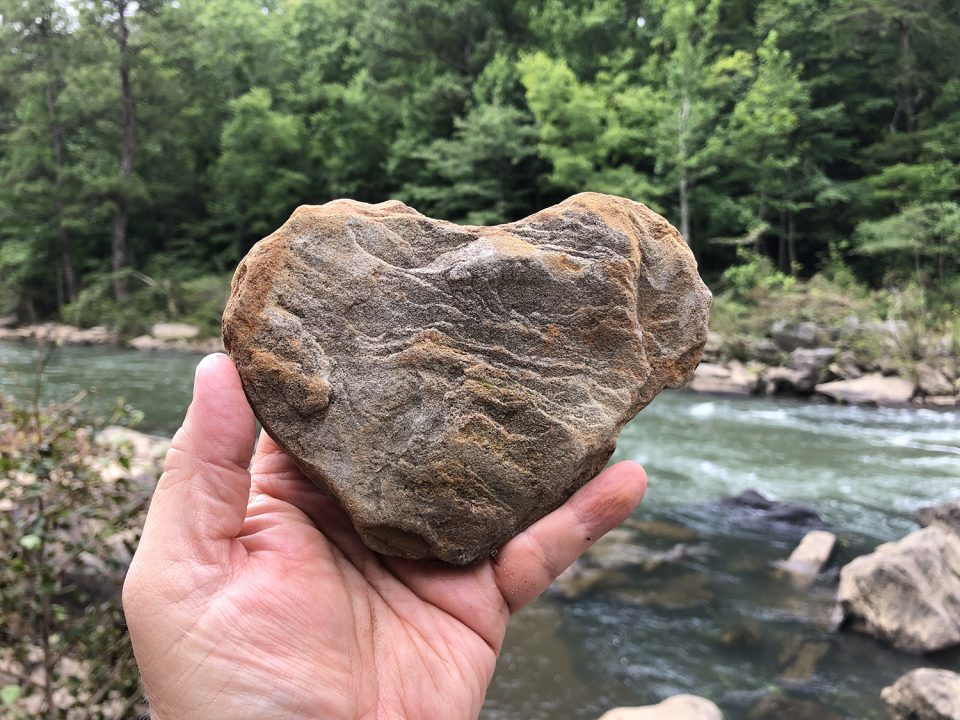 Picture of a heart-shaped stone found on a hike along the river's edge