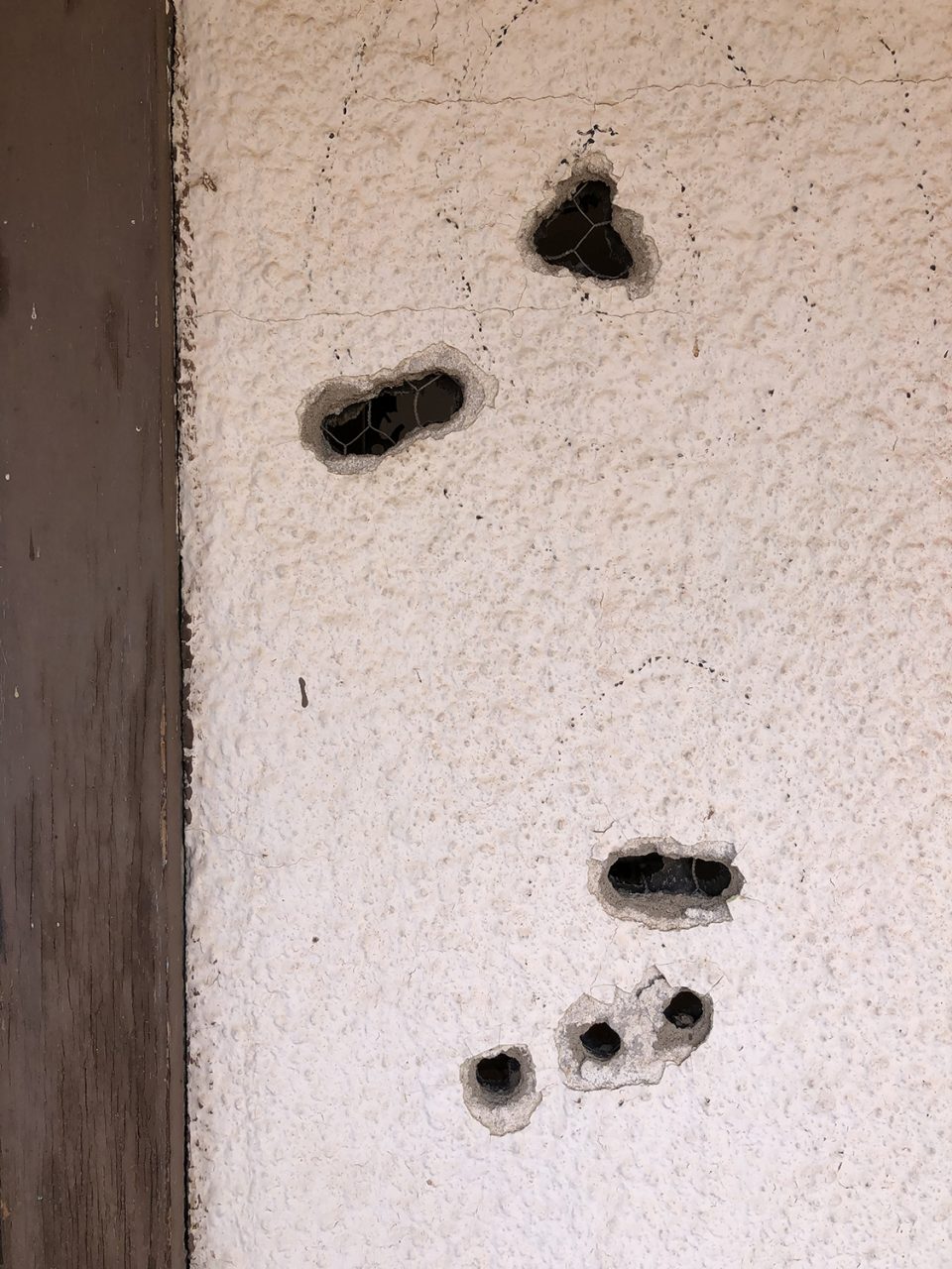 Bullet holes in the stucco walls of the Texas Longhorn Motel.