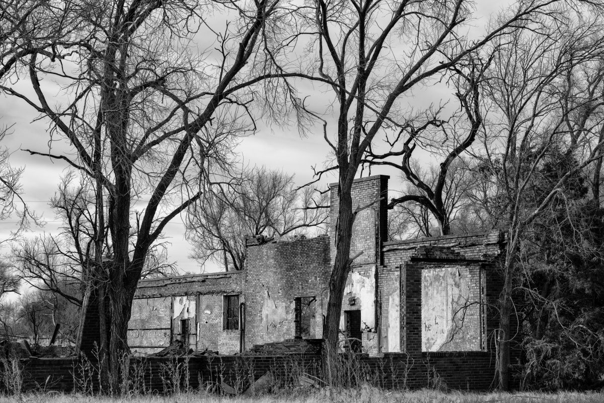 Black and white photograph of the ruined old school in Hext, Oklahoma. It was built in the 1930s by the WPA, and burned in April, 2021.