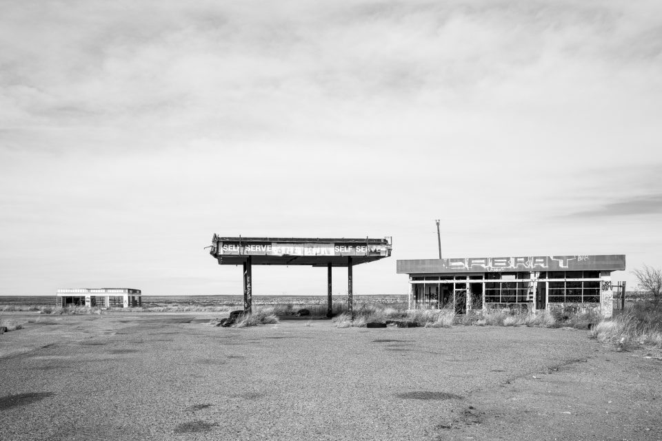 Black and white photograph of a modern gas station in ruins on the Glenrio exit of Interstate 40. Buy a fine art print.