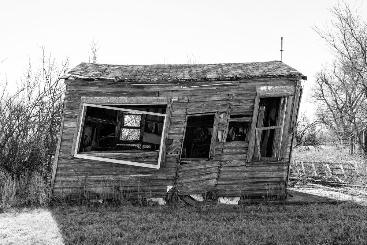 Black and white photograph of a leaning wooden shack on old Route 66 in Texola Oklahoma, shot by Keith Dotson.