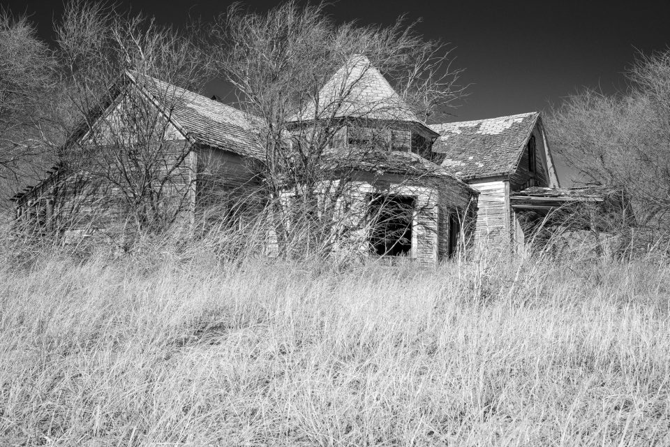 Remains of an abandoned house situated among tall grass in Texola, Oklahoma. 