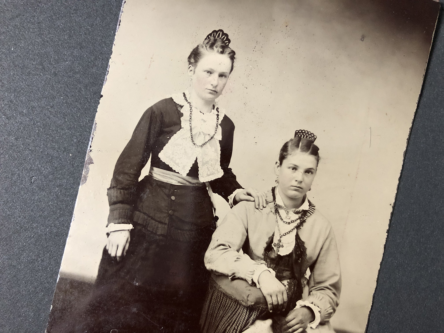 Looking at an antique tintype portrait of two young immigrant sisters ...
