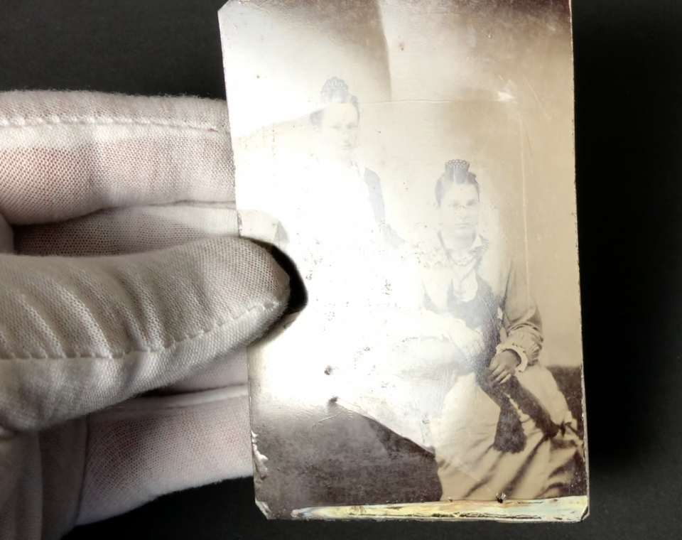 Looking at the old tintype in a raking light, we can see that it has been bent in several places.