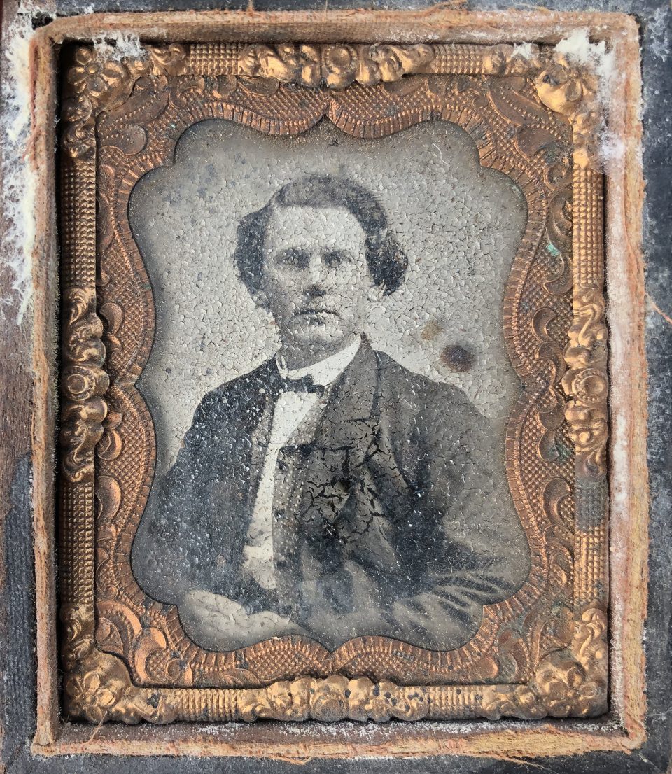 Badly degraded portrait of a young man, circa 1860s. The image layer is flaking and peeling away from the lacquered iron base plate.