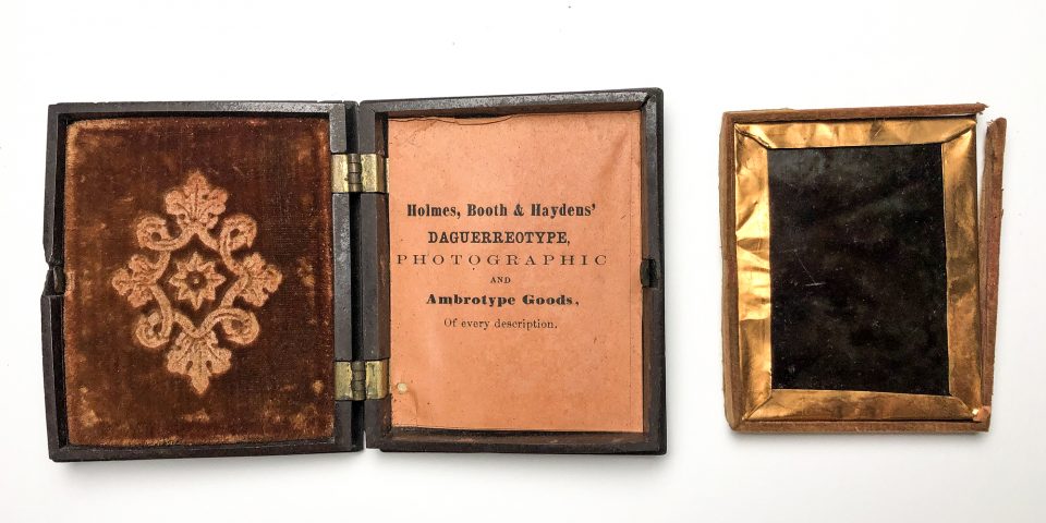 Inside the bottom of the thermoplastic case, behind the photograph, is a maker's mark for Holmes, Booth & Haydens.