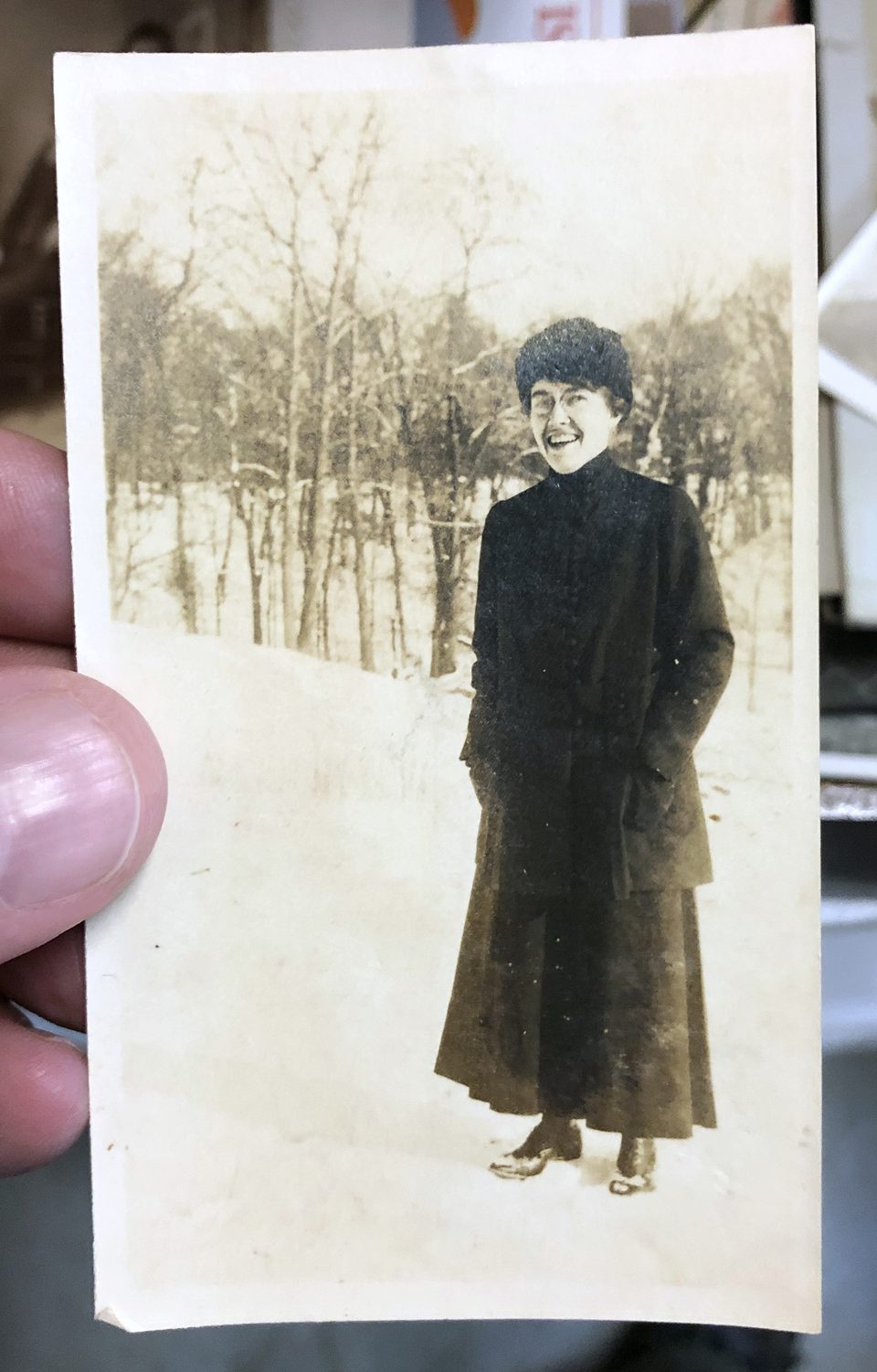 This early 1900s snapshot of a smiling woman standing in snow shows examples of yellowing and of silver mirroring (see example below).