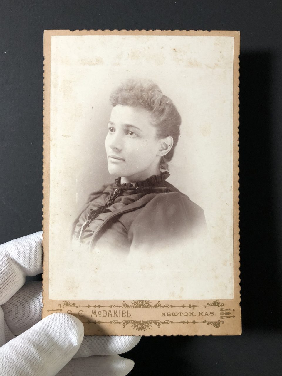 Cabinet card portrait of a young woman made in the late 1880s or early 1890s by photographer C.C. McDaniel in Newton, Kansas