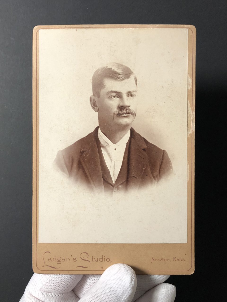 Portrait of a young man with a haircut and a handlebar mustache that were trendy for the time period -- the late 1880s (?)