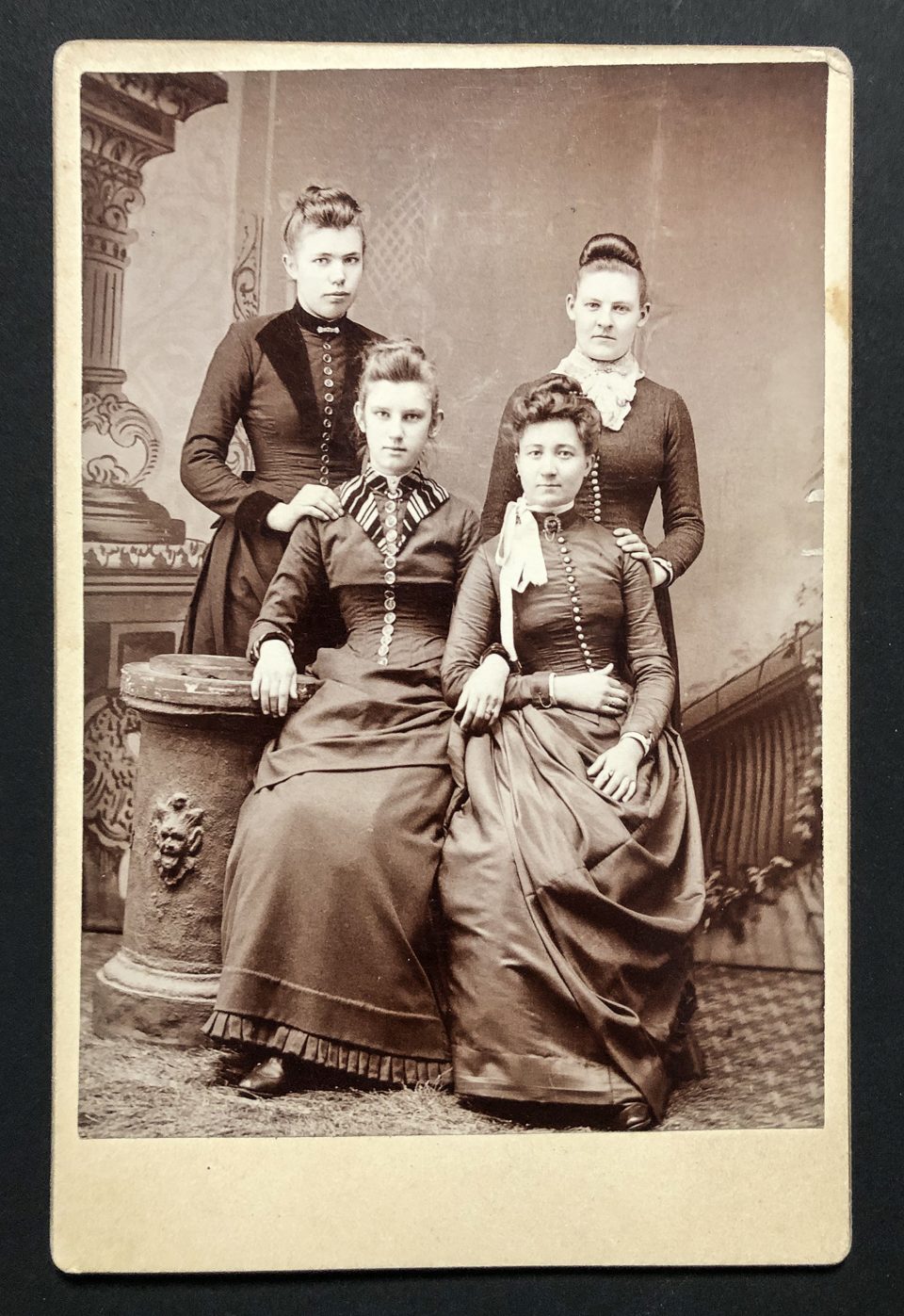This cabinet card by photographer J.A. Reitz features an albumen print portrait of four young ladies in long cresses, with all apparently confined within the tight confines of corsets.