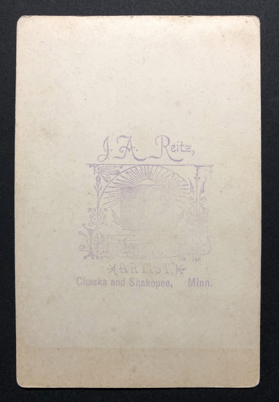 The artist's imprint on the back of the cabinet card appears to be hand stamped with purple ink.