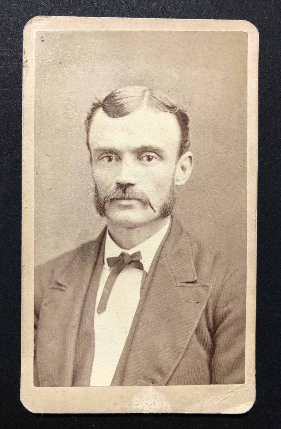 Carte de visite portrait of a man with a mustache and impressive sideburns by W.H Jacoby of Minneapolis, probably circa 1870s.