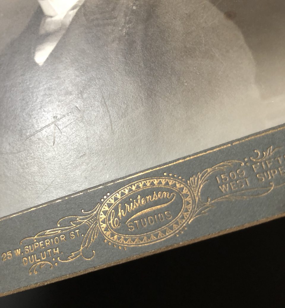 A close-up look at the gold foil stamped branding on the front of the mount card from Christensen Studios.