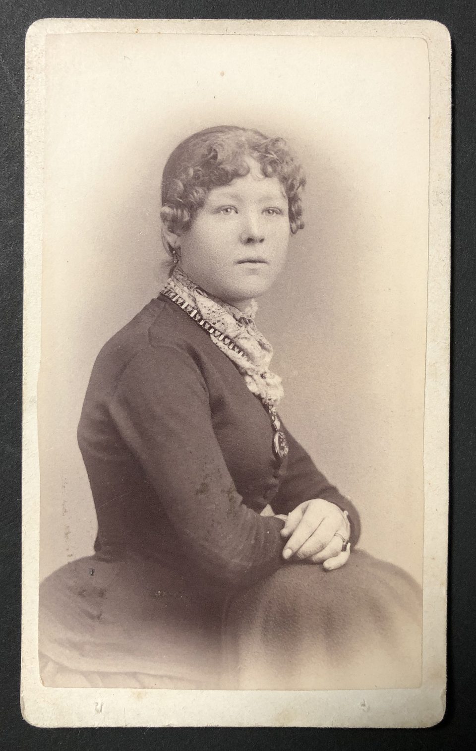 Portrait of a young woman with a lace color and a chunky bejeweled necklace, shot y the Hastings-based studio of Rust and Stafford.