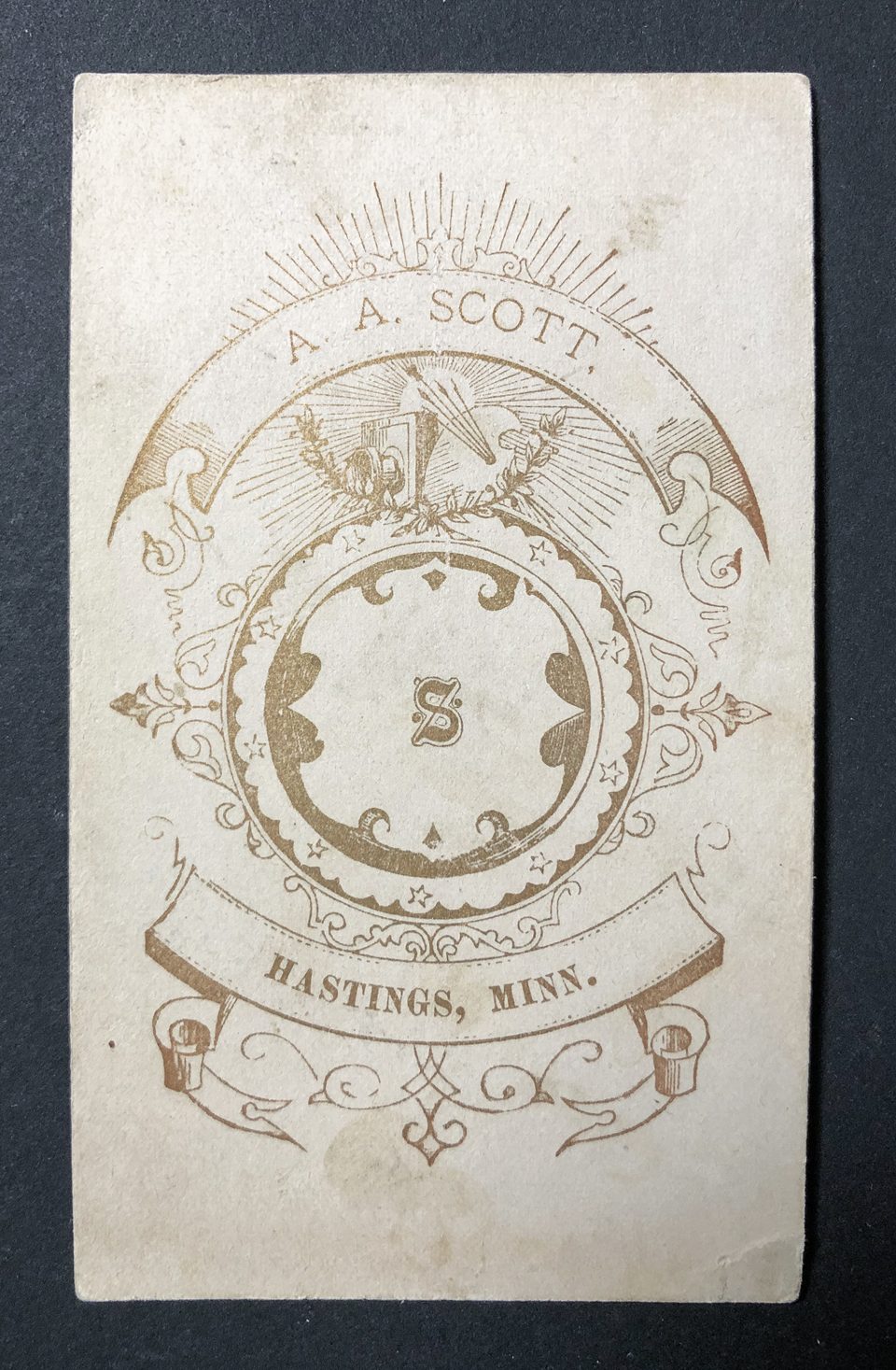 The back of this card was printed in gold ink and says "A.A. Scott, Hastings, Minn." There's a capital S centered amidst the ornate Sullivanesque graphic design.