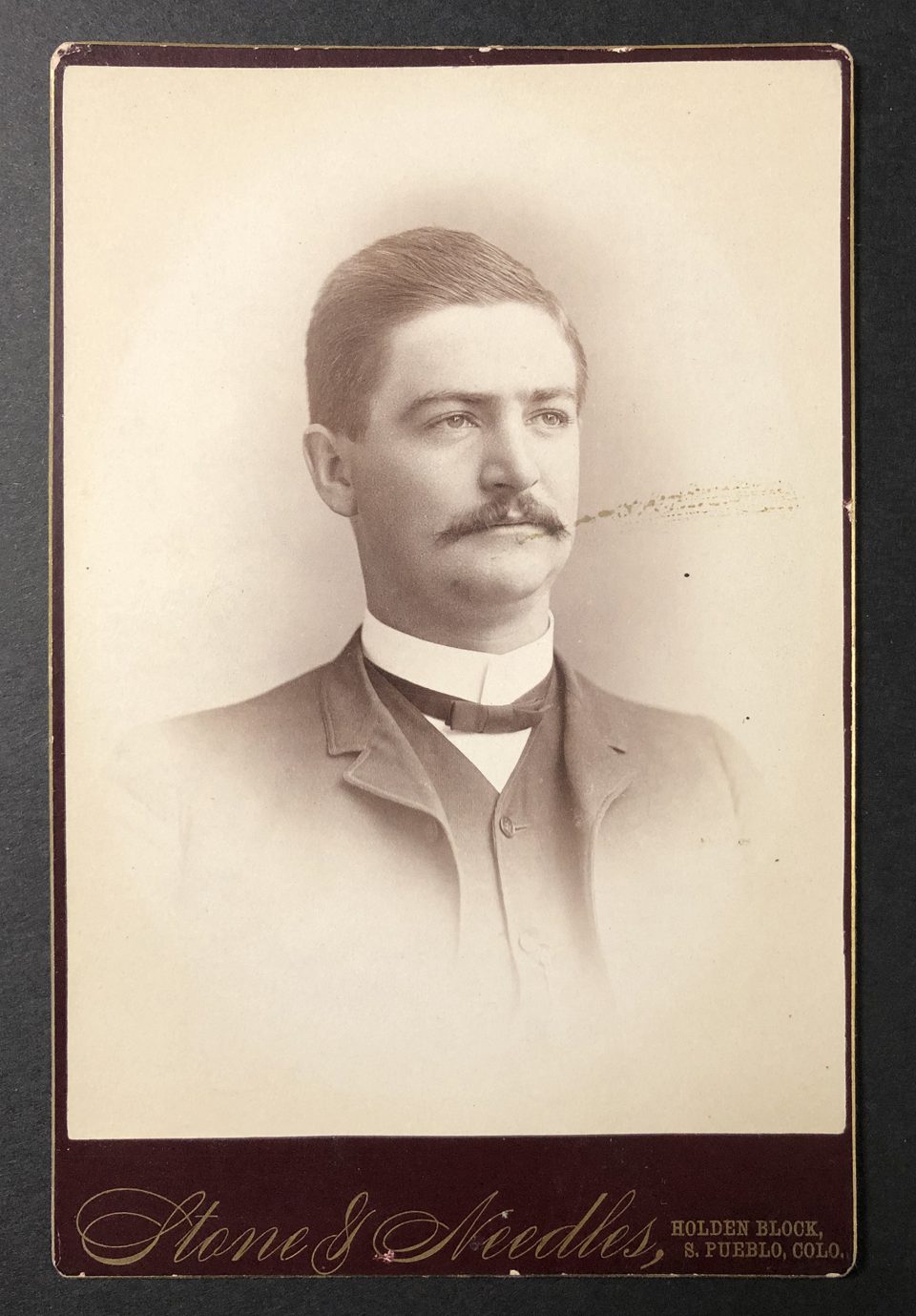 Cabinet card portrait of a well dressed gentleman with a mustache, photographed by the studio of Stone & Needles in South Pueblo,
