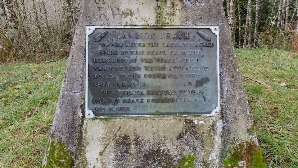 The marker on the base of the Cannon at Cannon Beach, Oregon. It tells how Cannon Beach got its name. Full text of the marker says, "Cannon Beach, named after the cannon washed ashore on this beach from the U.S.S. sloop of war "Shark" which was wrecked while attempting to leave the Columbia River September 10, 1846. This replica erected by the Cannon Beach Commercial Club, December 15, 1952."