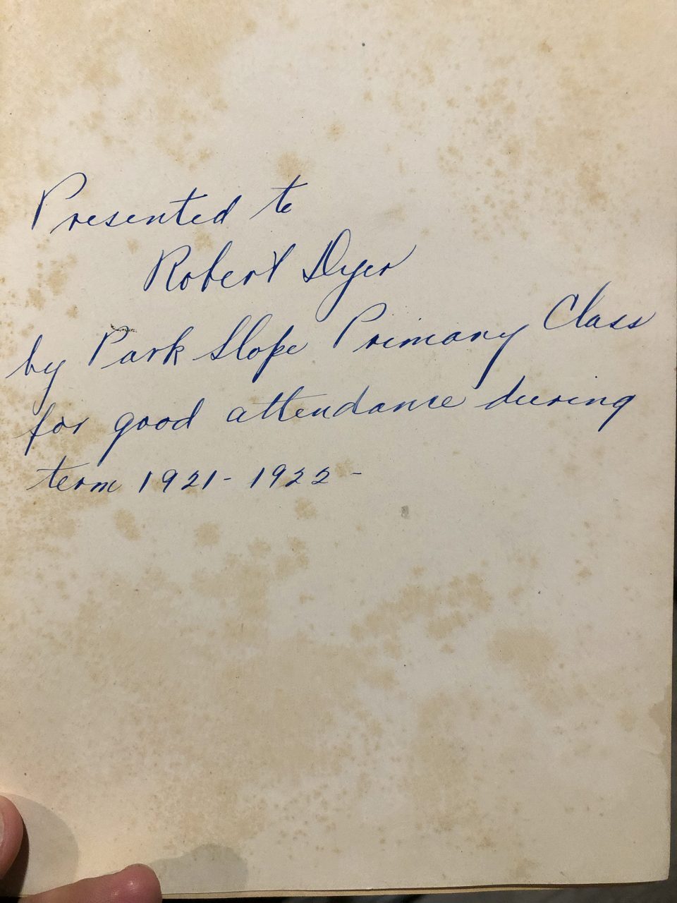 This beautifully written inscription says, "Presented to Robert Dyer by Park Slop Primary Class for good attendance during term 1921-1922." Park Slope is a neighborhood of Brooklyn, N.Y.
