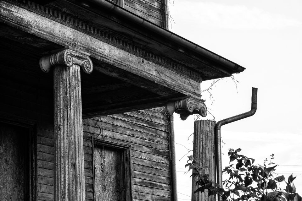 This photogrpah shows how one of the Ionic columns have become dislodged from the porch roof. Black and white photograph by Keith Dotson. Buy a fine art print here.