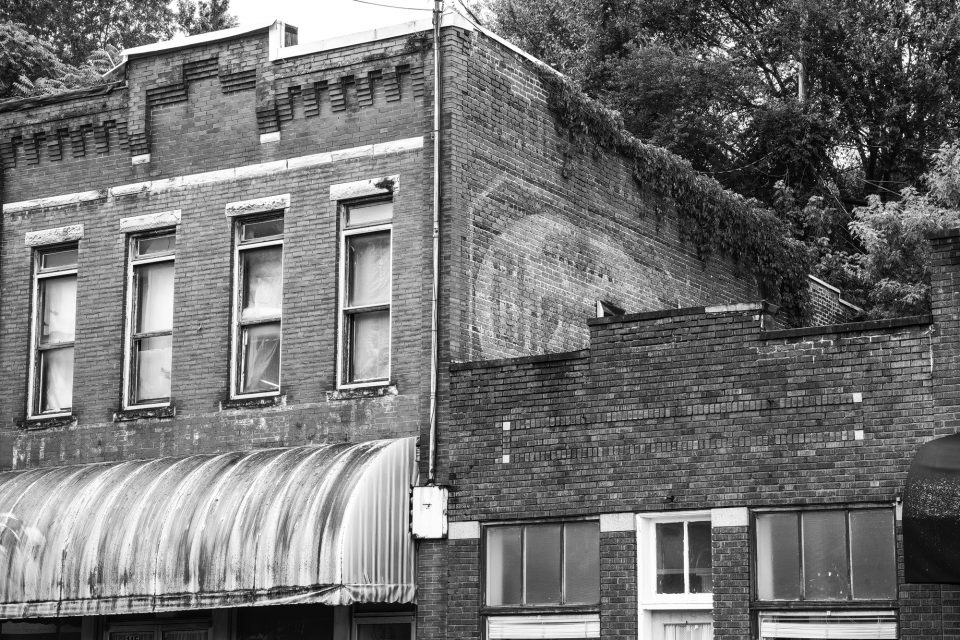 Vacant buildings and a faded ghost sign for a soft drink seen in downtown Jellico, Tennessee.