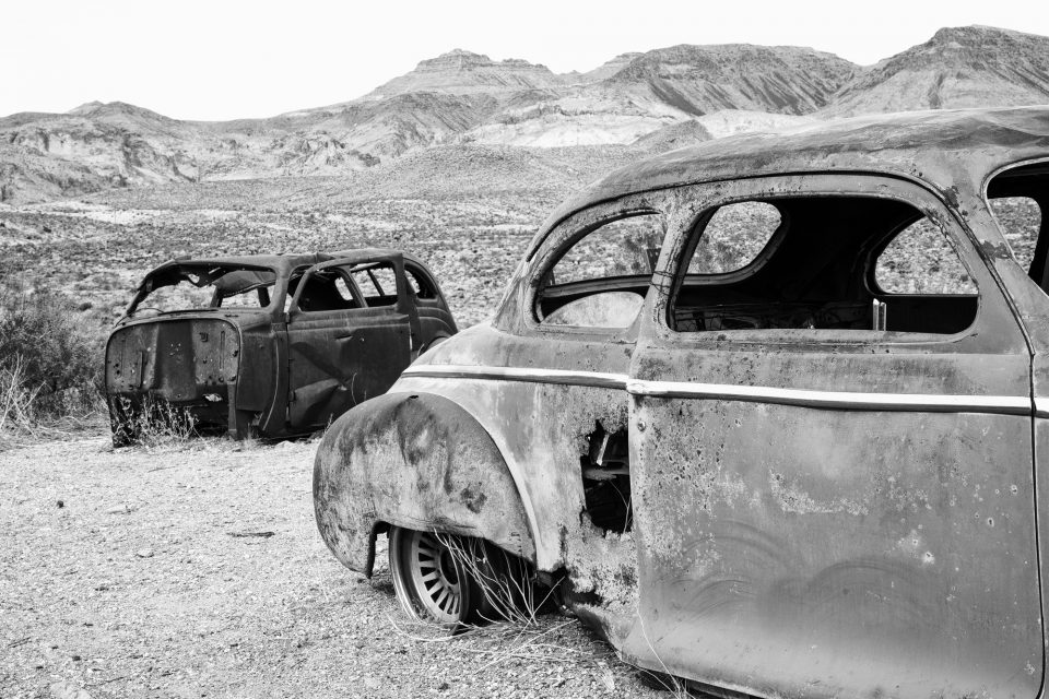 Rusty old junked cars at Cool Springs Station, Arizona. Black and white photograph by Keith Dotson.