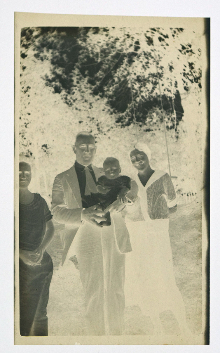 Film negative featuring a man holding an infant.