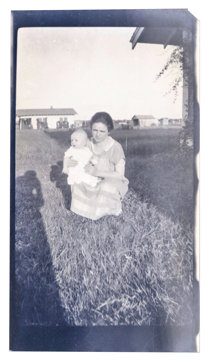 Black and white photograph of an unidentified mother and child kneeling in the grass. Could this be Wynona Williams?