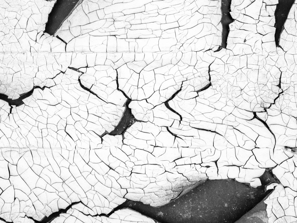 A landscape of cracked paint on the wall of one of the abandoned buildings in Uniontown. Black and white photograph by Keith Dotson.