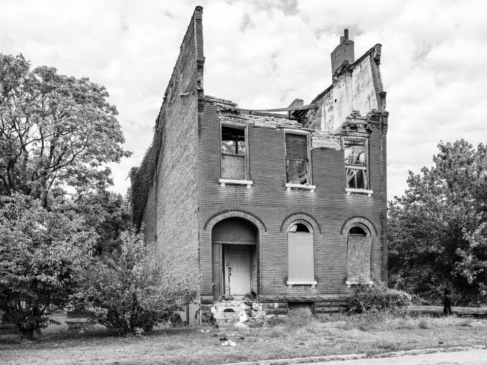 A collapsing house with clothing strewn across the front steps in the College Hill area of St. Louis.