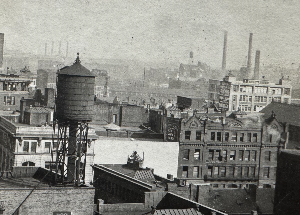 Snapshot of a large city, possibly New York. In the distance, large wall ads can be seen on some of the buildings.