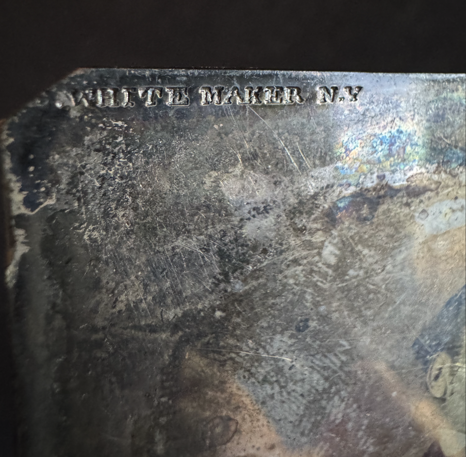 The maker's hallmark of Edward White of New York. White was a noted daguerreotpye photographer and maker of high-quality photo plates for daguerreotypes.