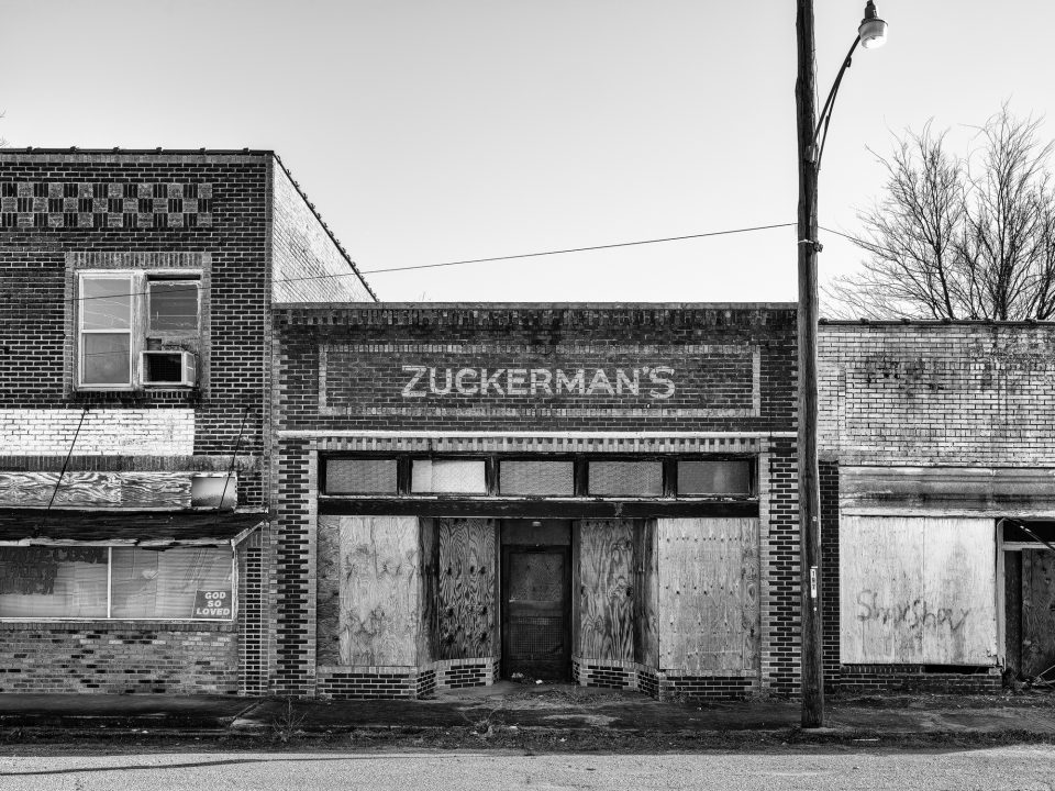 Zuckerman's storefront, now boarded-up in Hughes, Arkansas. Black and white photogrpah by Keith Dotson. Fine art prints are available.