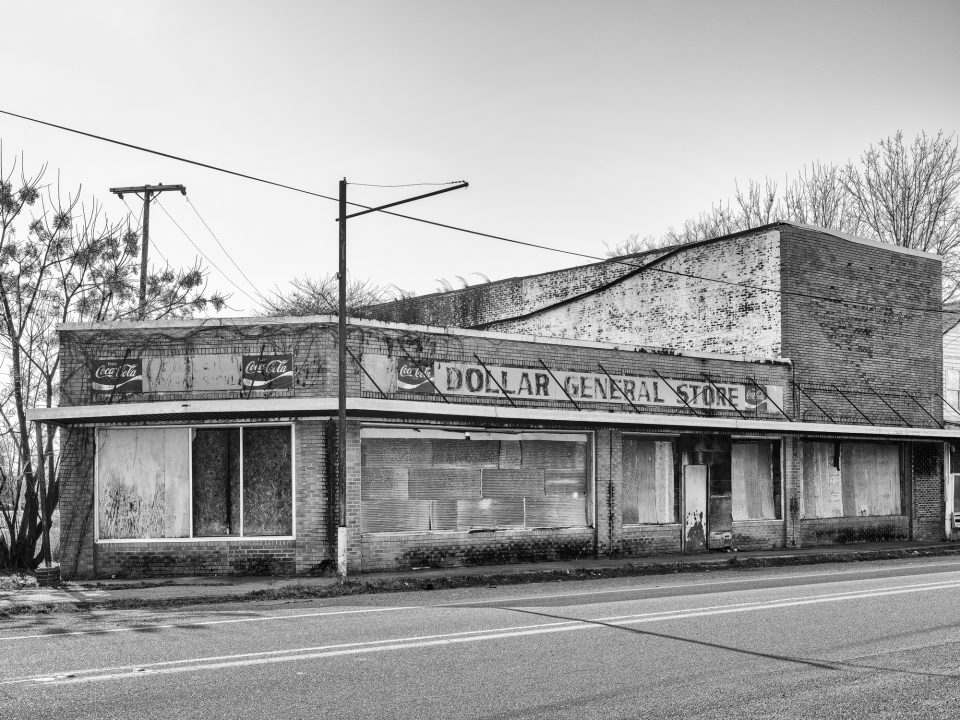 The old Dollar General Store with vintage Coca-Cola signs still in place, stands on the road leading into town. Black and white photograph by Keith Dotson.