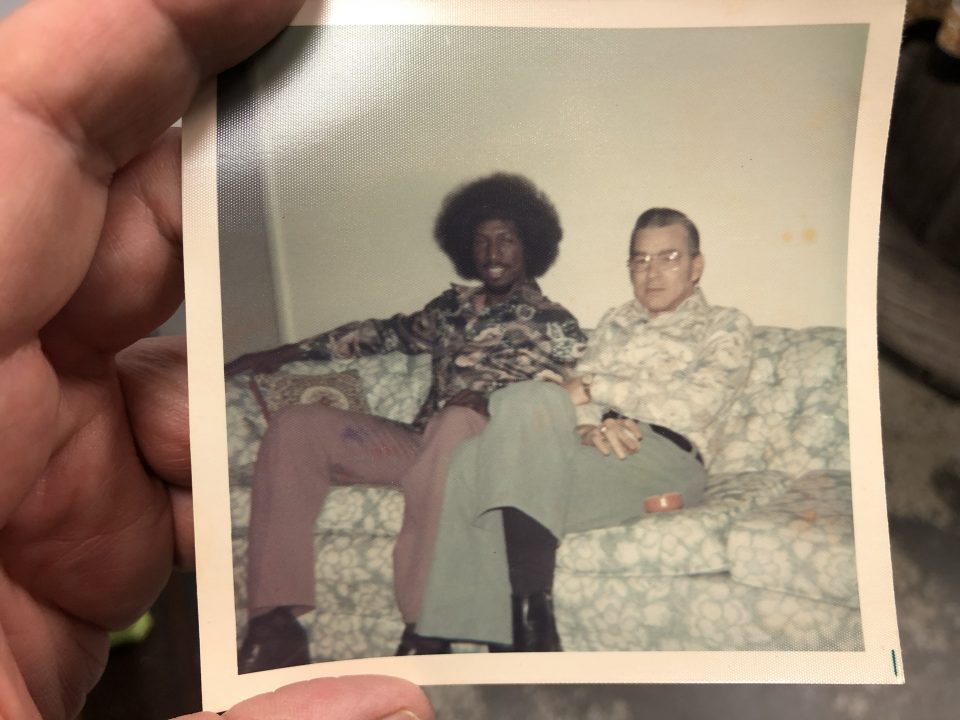 I love the coloration of this old snapshot of two guys sitting on a floral print sofa. The guy's shirt seems to match the sofa. Probably early 1970s. What do you imagine the story to be behind this photo?