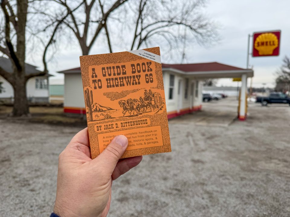 A Guide Book to Highway 66, 1946, by Jack D. Rittenhouse. Click to buy a copy on Amazon. Here I'm holding the classic travel guide to Route 66 in front of a gas station that Rittenhouse would certainly have seen on his travels -- the Soulsby Service Station in Mount Olive, Illinois.