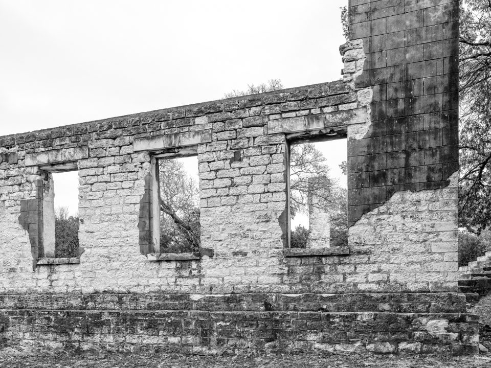 Black and white photograph of a row of large windows in the ruins of Salado College in Salado, Texas. Photograph by Keith Dotson.