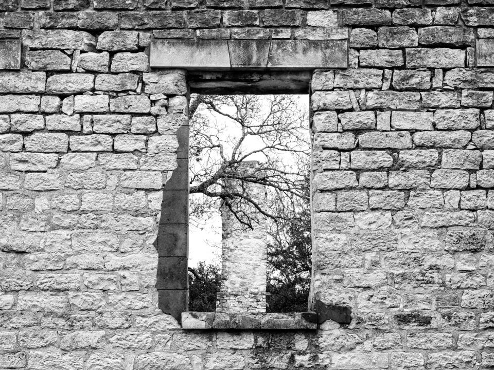 Black and white photograph of a large window in the ruins of Salado College in Salado, Texas. Photograph by Keith Dotson.