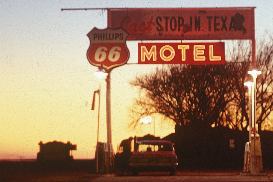 In this close-up we can see someone getting a fill-up at the pumps. A gallon of gas in 1967 would have cost somewhere between 31 and 33 cents. On the left can be seen the silhouette of a monument sign by the road, which I think may have marked the state line.