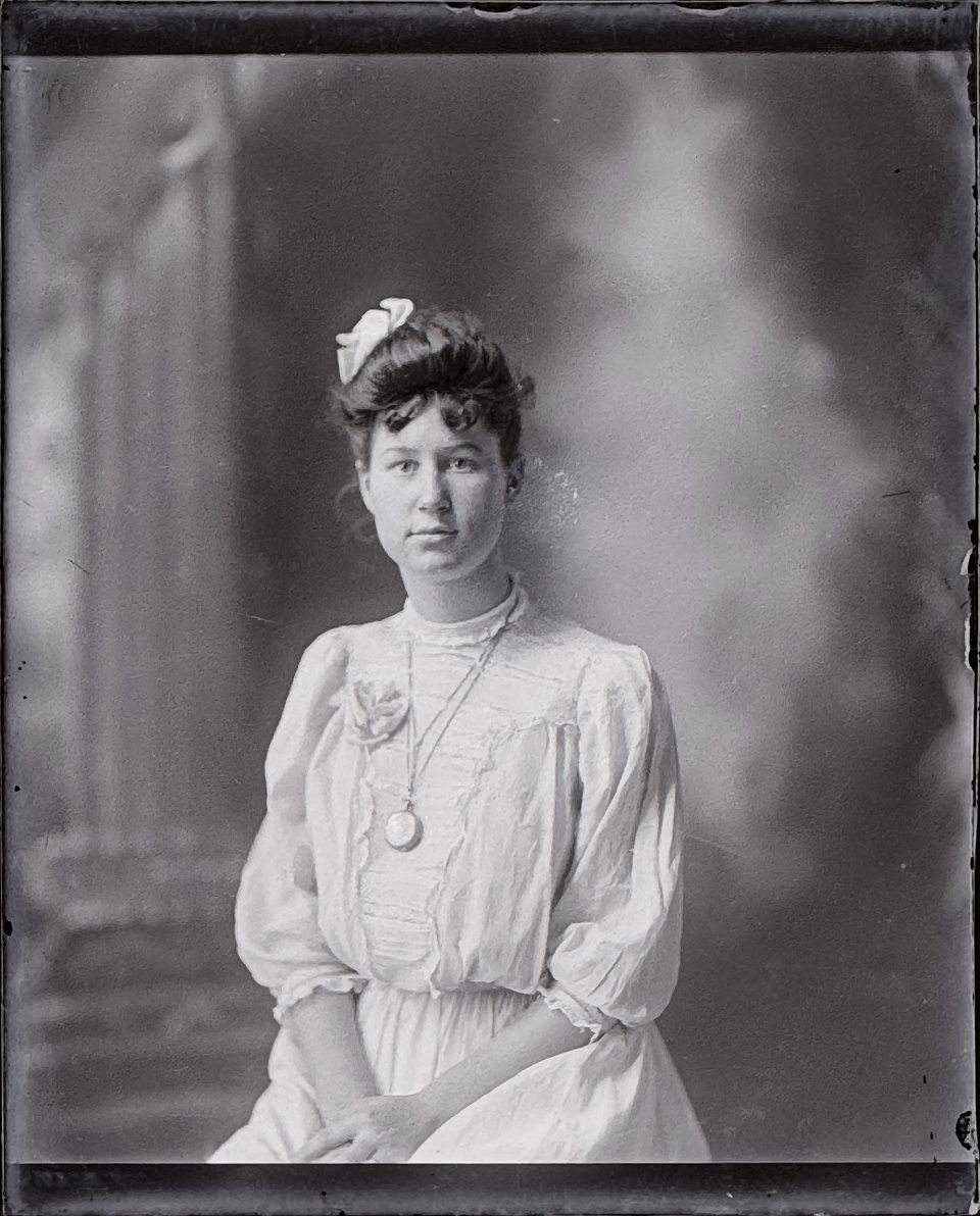 This unidentified young woman wears a locket or possible a pocket watch on a chain around her neck.