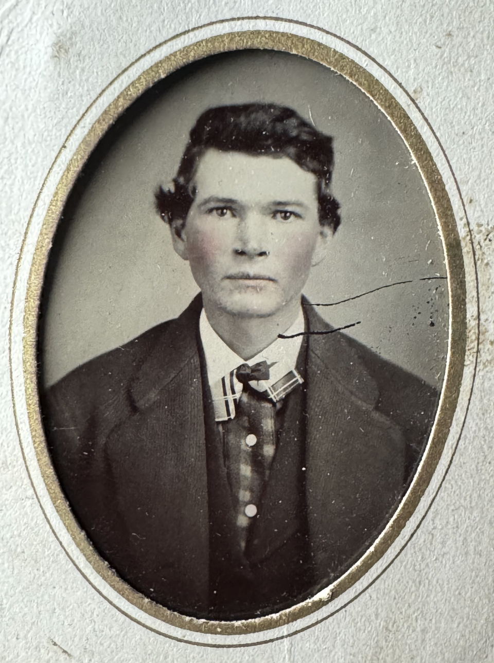 Tintype portrait of an unidentified young man with a touch of pink paint added to his cheeks.