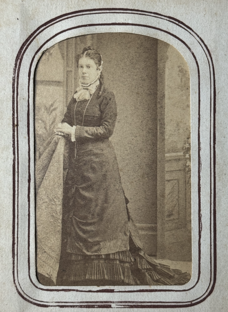 A beautiful young woman in a floor length dress, labeled in pencil below her portrait as being Cora Spaulding.