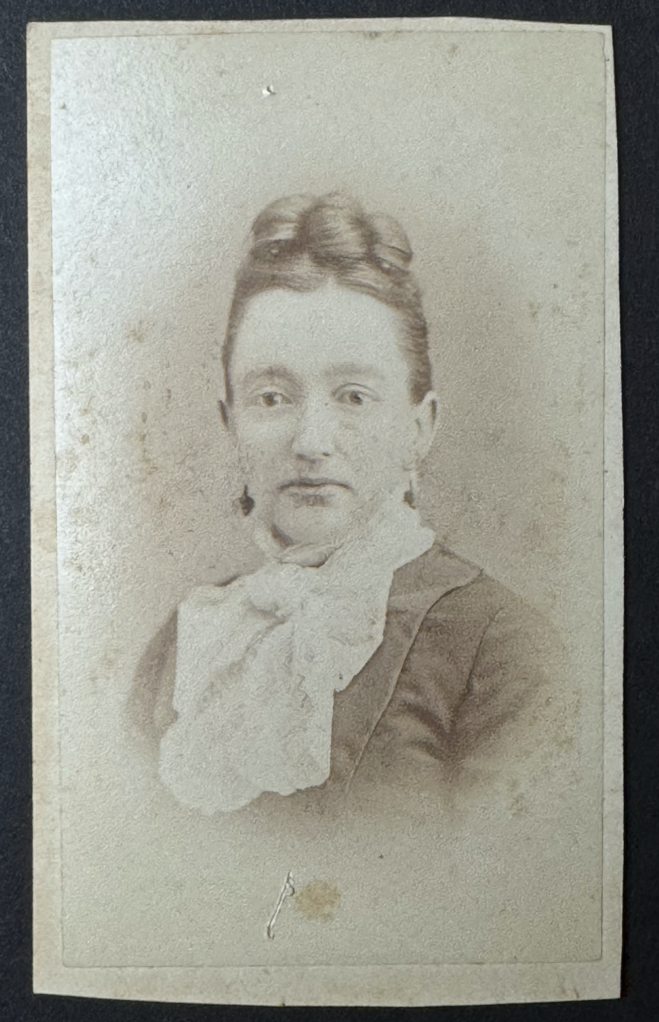 Portrait of a young woman whose name was inscribed in pencil beneath her picture -- Sylvia Cox. This carte de visite was made by the studio of C.A. Cross, of Sandusky, Ohio -- imprint shown below.