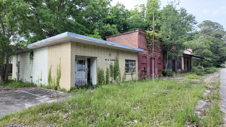 A view of the abandoned buildings in Seale, Alabama, with the 1962 post office building shown in the front.