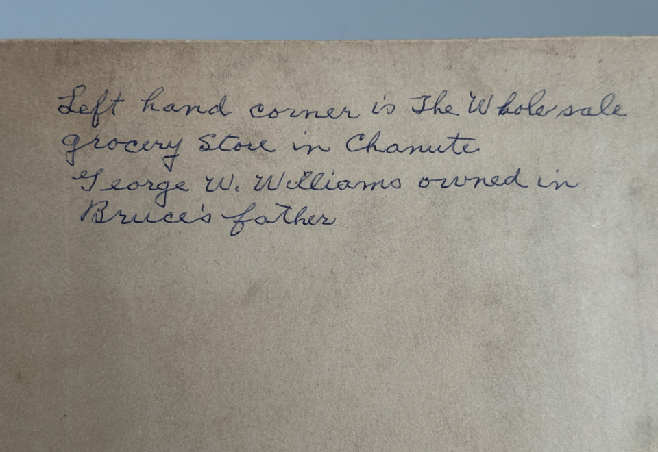 On the back of the mount is an inscription written in black ballpoint ink that says "Left hand corner is the wholesale grocery store in Chanute, George W. Williams owned in (sic) Bruce's father."